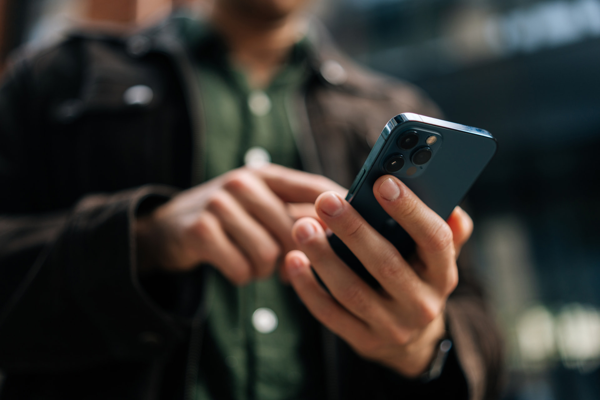 Close-up of a person using a smartphone on a city street
